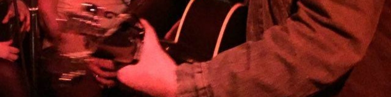 Typ mit Gitarre spielt bei den Eisen-Geburtstagsfeierlichkeiten